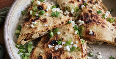 Quesadillas de tinga servidas cortada con cebollino y queso