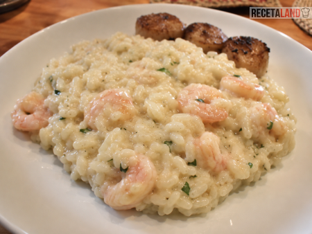 Risotto de camarones presentado con perejil y guarnición