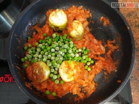 Sofriendo la cebolla, el tomate, las alcachofas y los guisantes