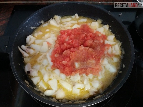 Añadiéndole el tomate junto con la sepia y la cebolla a la sepia 