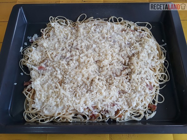 Espaguetis con el queso rallado encima de la Bechamel