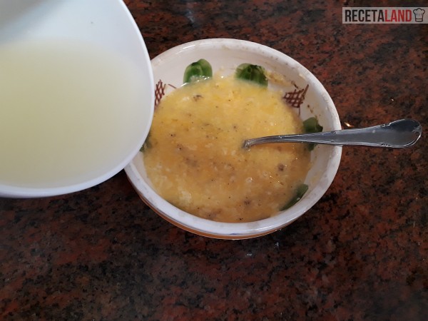 Añadiéndole agua de la cocción a la yema de huevo batida