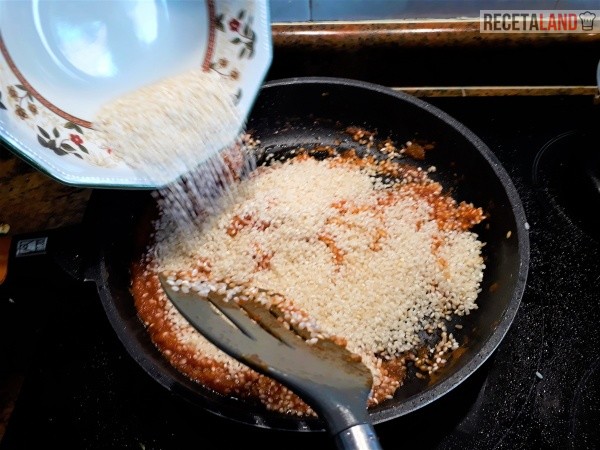 Añadiéndole al arroz al tomate para mezclarlo