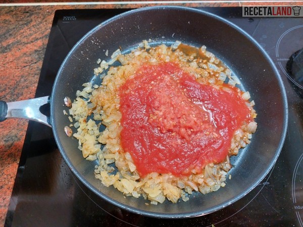 Añadiéndole el tomate a la cebolla