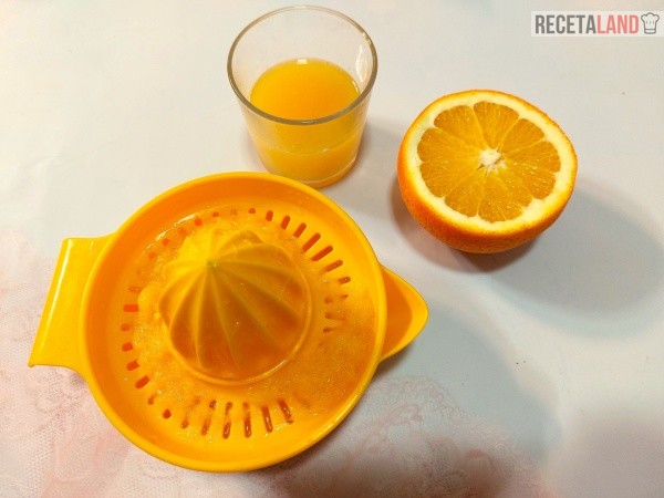 Exprimiendo el zumo de naranja para añadírselo a la masa